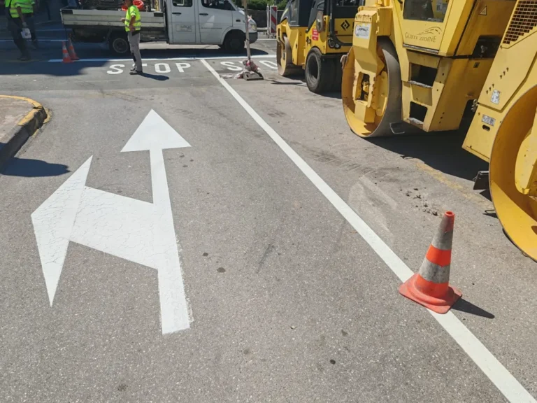 Svježe iscrtane bijele strelice za skretanje na asfaltiranoj površini