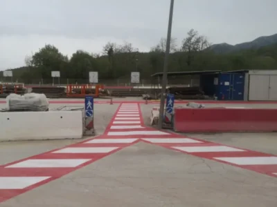 Crveno-bijela horizontalna signalizacija za pješake iscrtana na betonskom platou Kvarner