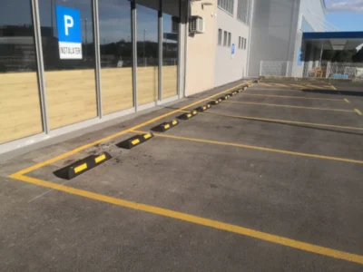 Crno-žuti gumeni parkirni graničnici postavljeni na asfaltirano parkiralište ispred objekta FERO TERM u Puli.