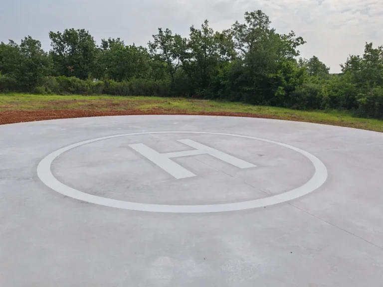 Detaljan prikaz svježe obojane oznake helidroma s jasnim i ravnim linijama na betonskoj podlozi.