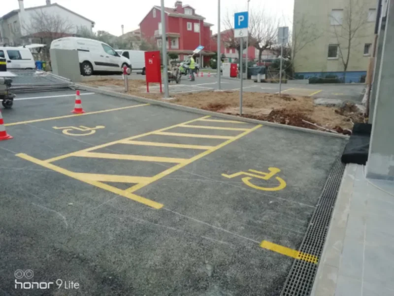 Žuta horizontalna signalizacija i piktogrami za invalidska parkirna mjesta na POS stanovima u Rovinju