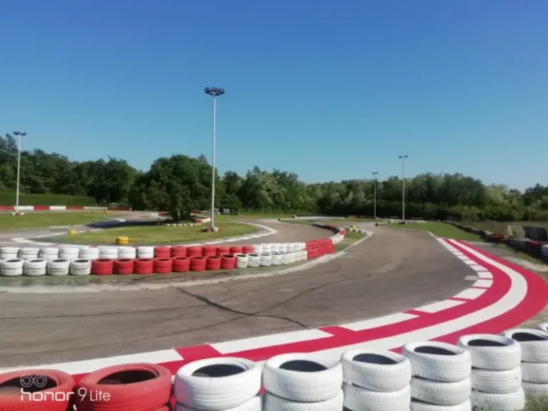 Pogled na zavoj karting staze s jasnom horizontalnom signalizacijom