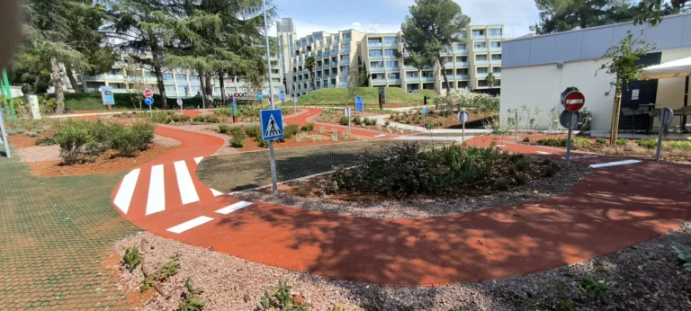 Info totem za posjetitelje i iscrtane bijele strelice na asfaltiranom dijelu poligona.