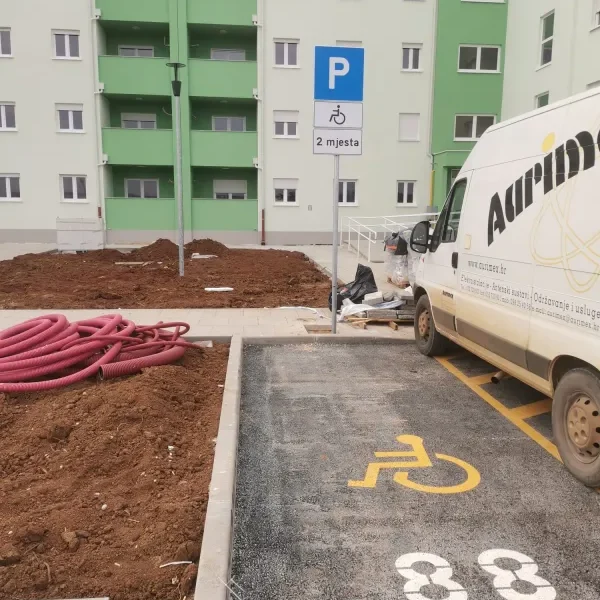 Iscrtana invalidska parkirališna mjesta žutom bojom i postavljen prometni znak za osobe s invaliditetom na APN stanovima u Umagu.