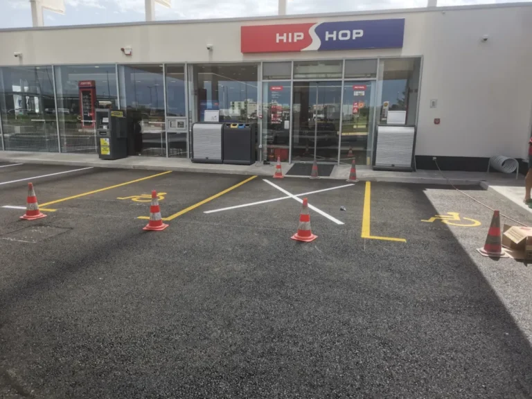 Žutom bojom označena parkirna mjesta za osobe s invaliditetom ispred trgovine benzinske postaje.