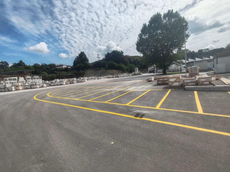 Veliko parkiralište sa žutim linijama prilagođeno za organiziran smještaj vozila zaposlenika i posjetitelja.