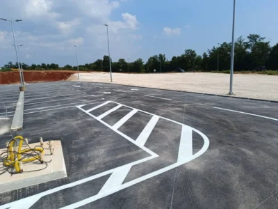 Precizno iscrtane bijele parkirne linije i prometni otok na novom asfaltu parkirališta Plodina u Poreču.