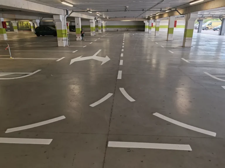 Široki prikaz podzemnog parkirališta s novoobnovljenom i jasno vidljivom horizontalnom signalizacijom.