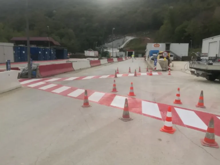 Široki prikaz industrijskog gradilišta s novoobilježenim crveno-bijelim pješačkim stazama
