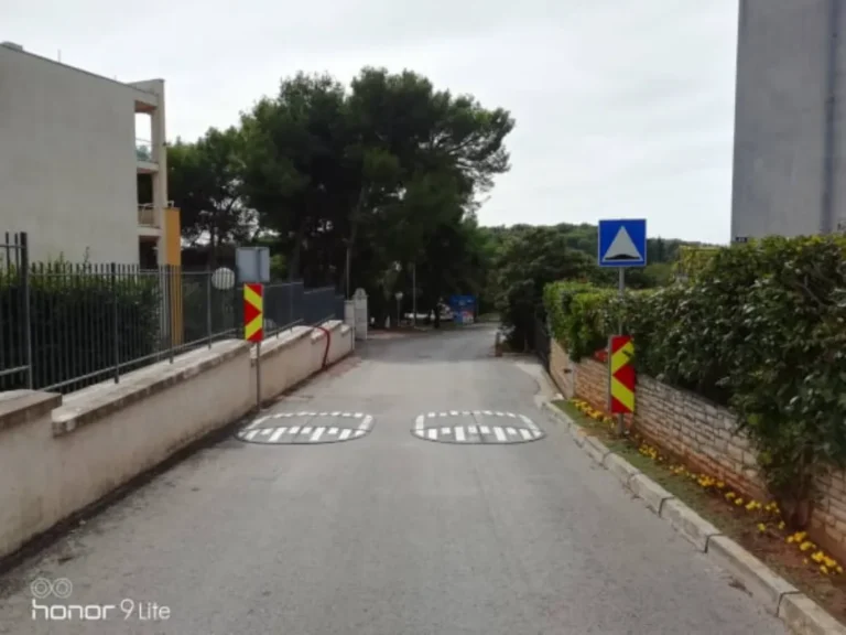 Ugrađene jastučaste izbočine za smirivanje prometa s pratećom vertikalnom signalizacijom na cesti.