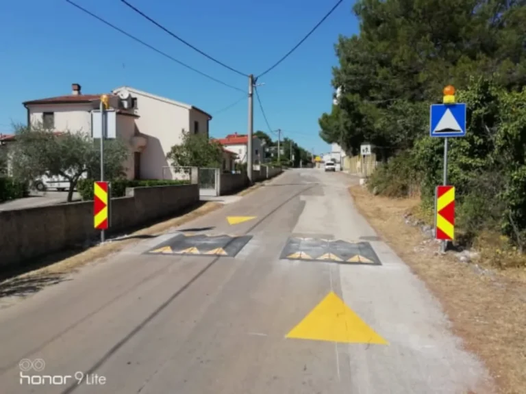 Pogled na cestu s postavljenim jastučastim izbočinama i žutim trokutima upozorenja