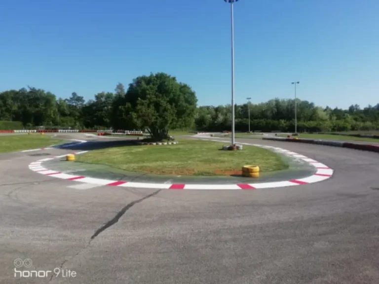 Osvježene crveno-bijele linije uz rub travnjaka na karting stazi