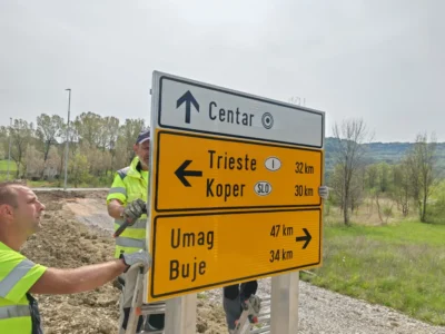 Radnici montiraju veliku putokaznu ploču s oznakama za Trst, Koper, Umag i Buje