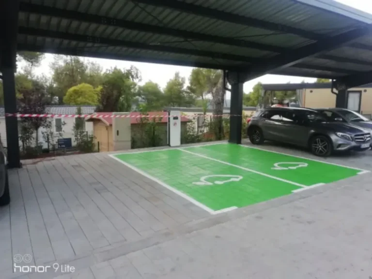 Zelena horizontalna signalizacija za EV vozila izvedena na betonskim opločnicima ispod nadstrešnice