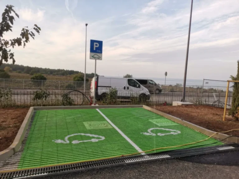 Zelena parkirališna mjesta s oznakama za punjenje električnih vozila i pripadajućim znakom