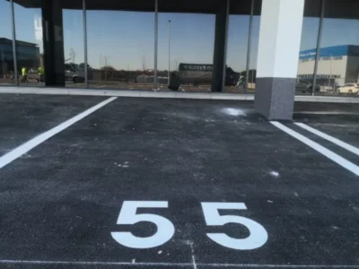 Svježe iscrtane bijele linije i broj 55 na novom asfaltu parkirališta u Puli.