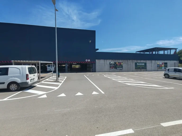 Iscrtane oznake za kretanje vozila i pješačke staze na ulazu u vanjsko parkiralište trgovačkog centra.