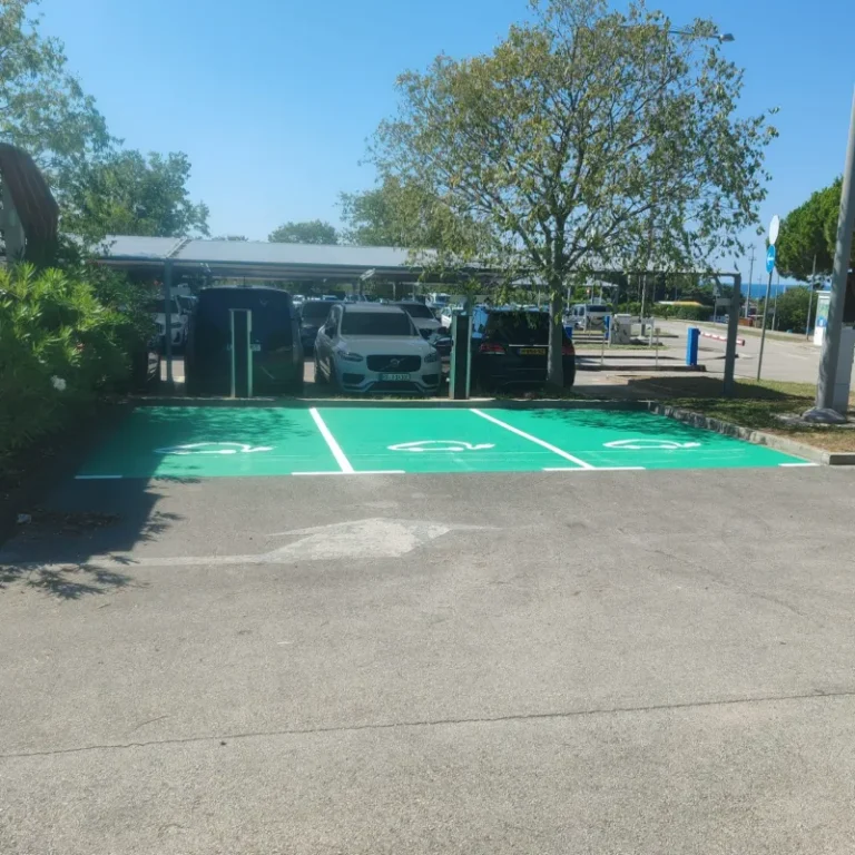 Tri zelena parkirna mjesta za električna vozila na asfaltnoj podlozi u kampu