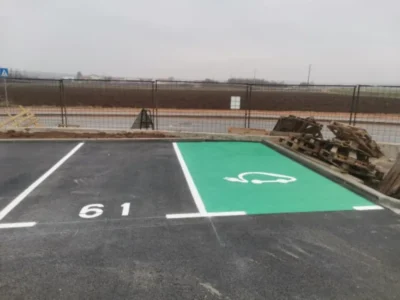 Horizontalna signalizacija za električna vozila sa zelenom podlogom i bijelim simbolom automobila.