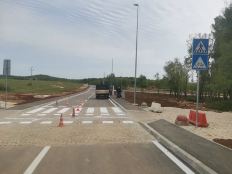 Iscrtan pješački prijelaz s naglašenim crveno-bijelim elementima na novoj cesti