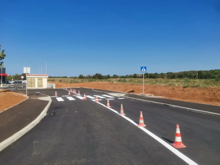Svježe obojani pješački prijelaz zaštićen čunjevima i novi prometni znak za pješake.
