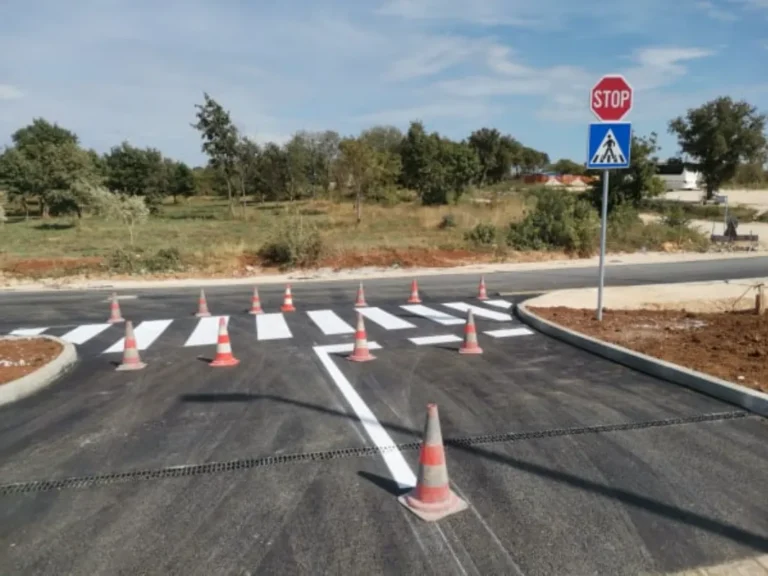 Svježe iscrtan pješački prijelaz i postavljeni prometni znakovi STOP i pješački prijelaz.