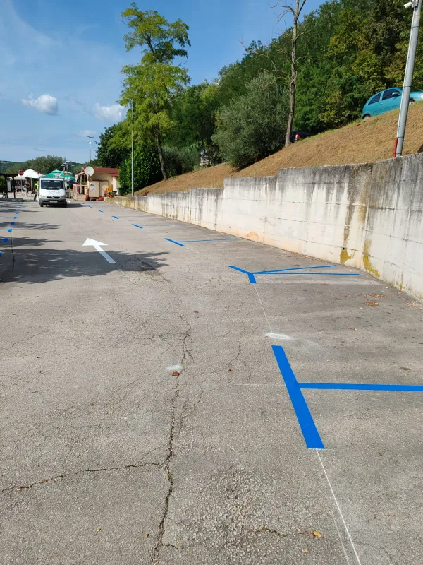 Horizontalna signalizacija plavih parkirnih mjesta uz potporni zid