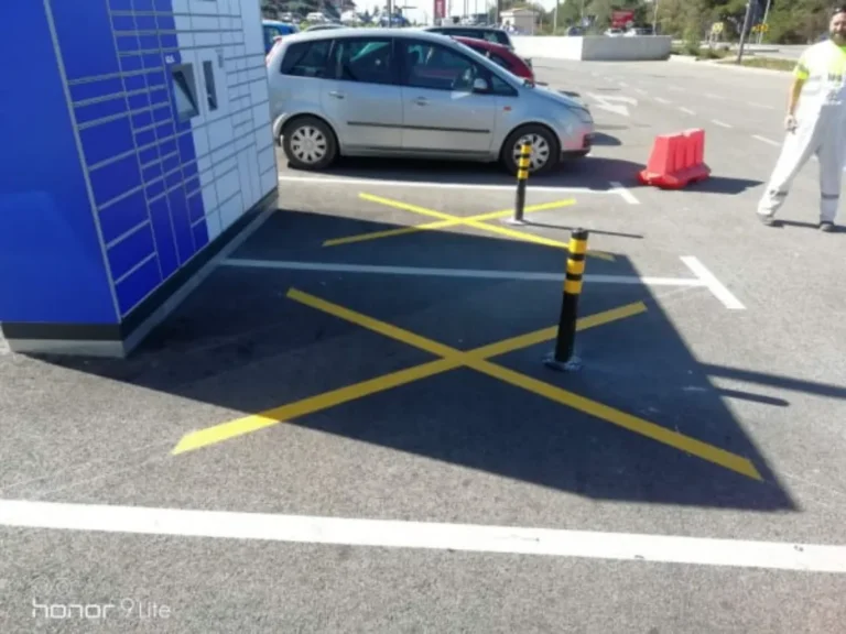 Djelatnik provjerava postavljenu prometnu opremu i horizontalnu signalizaciju na parkiralištu.