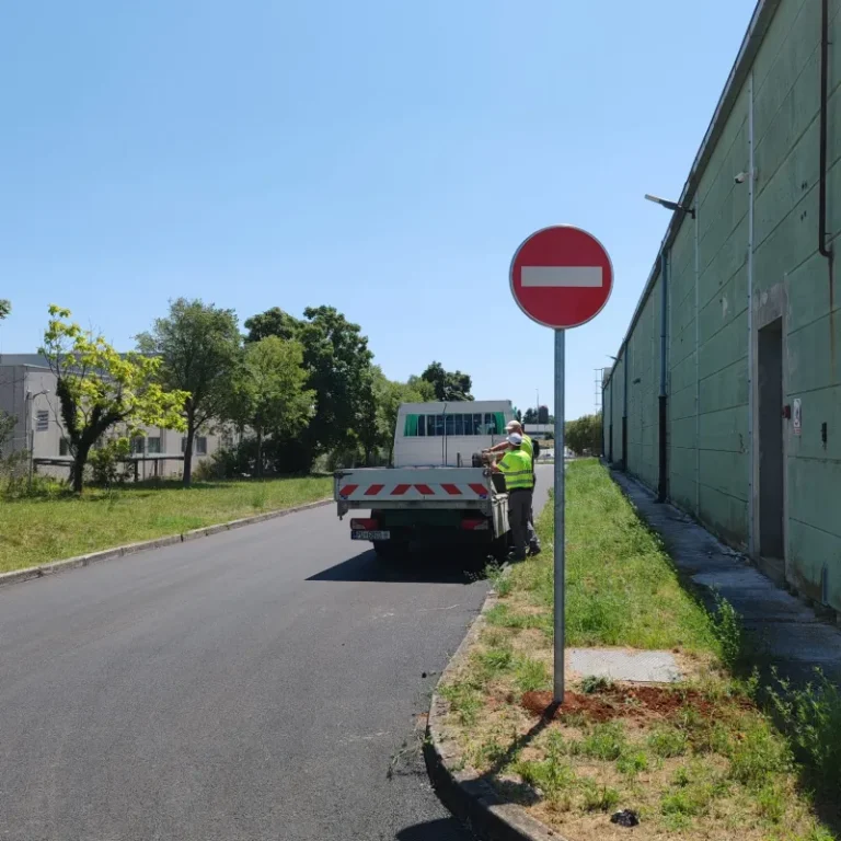 Djelatnici tvrtke LIČILAC d.o.o. postavljaju prometni znak zabrane smjera uz cestu