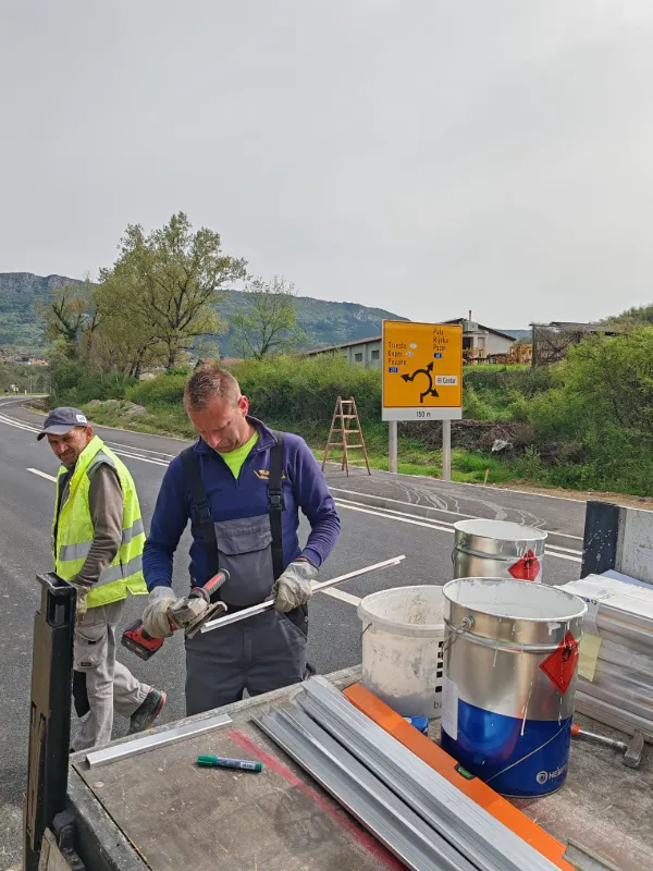 Radnici režu metalne profile za postavljanje prometnih znakova