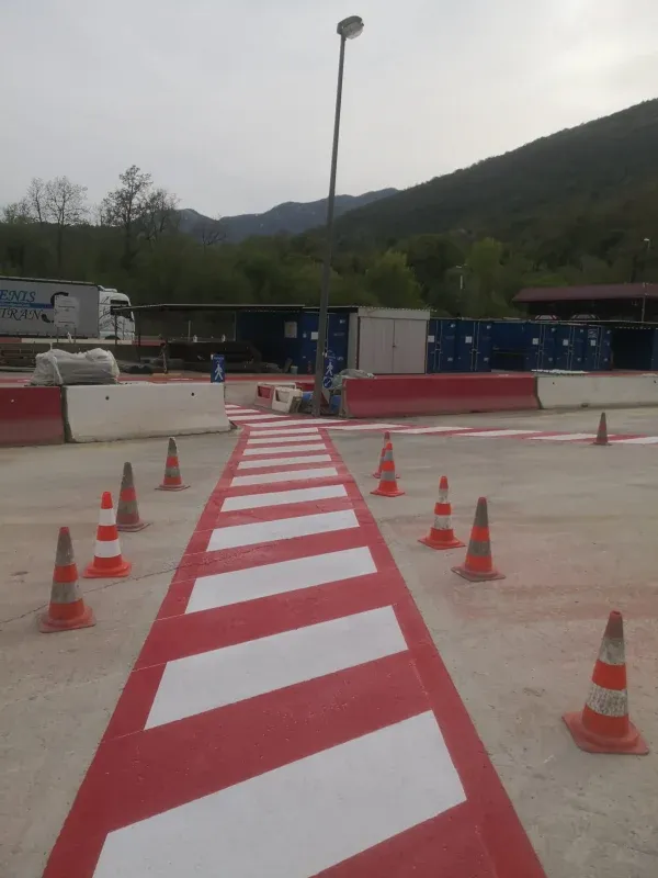 Prometni čunjevi postavljeni za zaštitu svježe obojane crveno-bijele horizontalne signalizacije