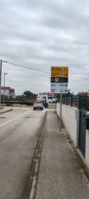 Stup s više turističkih putokaza koji usmjeravaju prema Puli, hotelima i kampovima