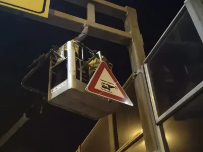 Radnik tvrtke Ličilac d.o.o. u auto-košari montira vertikalnu signalizaciju na visinski portal