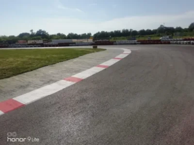 Široki zavoj na karting stazi označen uočljivim rubnim trakama