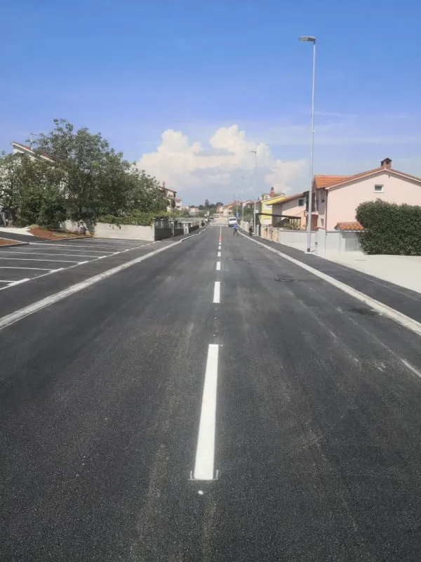Svježe iscrtana isprekidana bijela središnja linija na novom asfaltu u ulici B. Gumpca