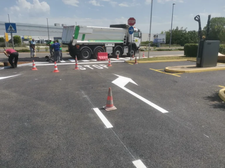 Oznaka STOP i strelice za skretanje iscrtane na izlazu s benzinske postaje.