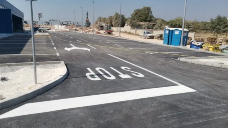 Velika oznaka STOP na kolniku uz usmjeravajuću strelicu za izlaz s parkirališta
