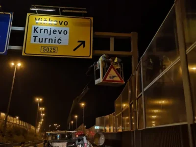 Terensko vozilo tvrtke s opremom za postavljanje prometnih znakova na noćnom gradilištu