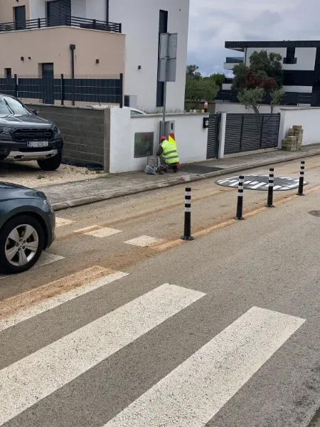 Radnik tvrtke LIČILAC d.o.o. postavlja jastučaste izbočine i crno-bijele fleksibilne stupiće u Premanturi.