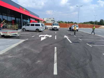 Obilježavanje usmjernih strelica za siguran protok prometa ispred ulaza u trgovački centar.