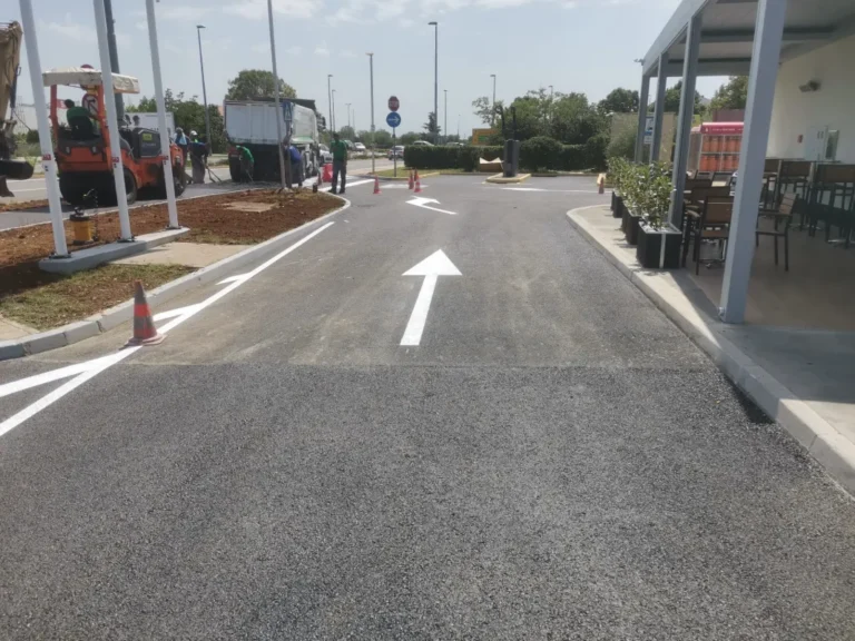 Iscrtane strelice za usmjeravanje prometa prema autopraonici na benzinskoj postaji.