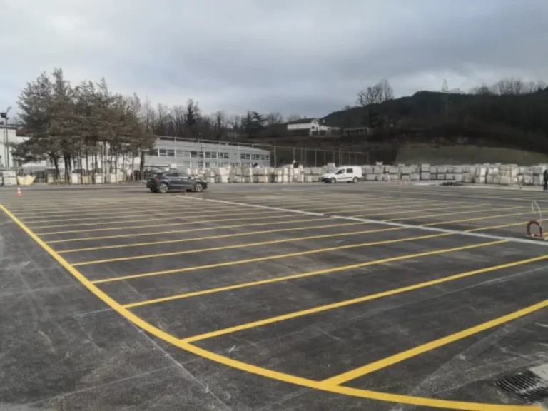 Široki prikaz velikog parkirališta s iscrtanim žutim linijama