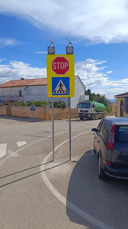 Visoko uočljiv prometni znak STOP i pješački prijelaz sa solarnim panelima na vrhu stupa