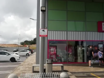 Znak obavijesti o videonadzoru pričvršćen na modernu fasadu trgovačkog centra