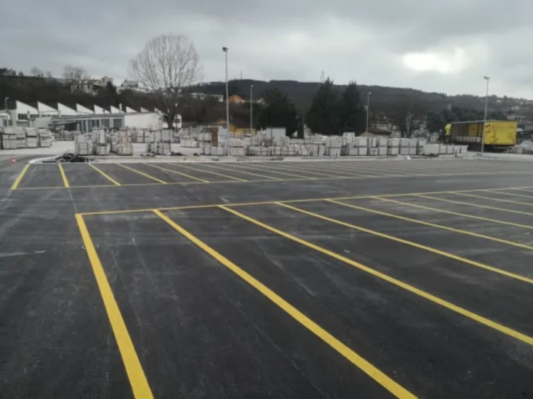 Niz žutih parkirnih mjesta na novom asfaltu