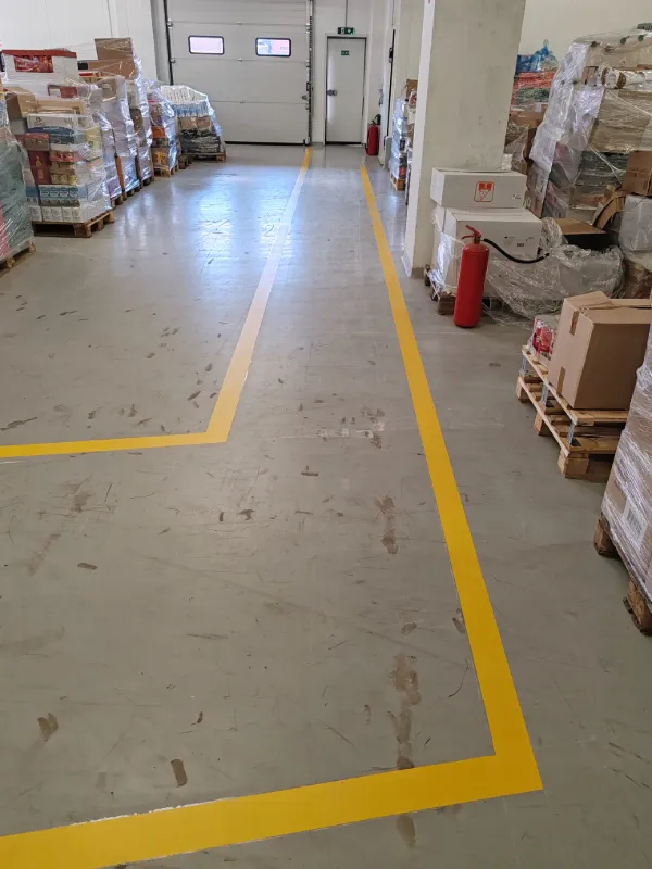 Jasno iscrtane žute linije uz rubove glavnog skladišnog prolaza