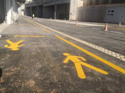 Žuta horizontalna signalizacija koja prikazuje pješake i označava sigurne pješačke koridore.