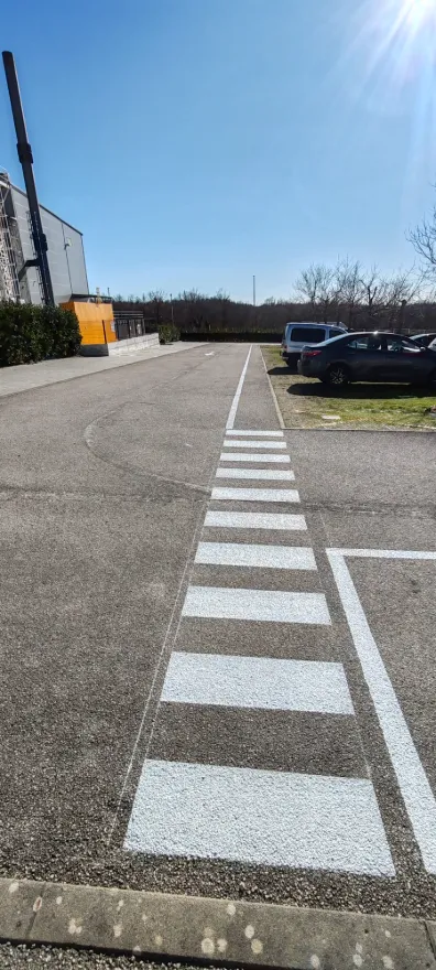 Detalj iscrtanog pješačkog prijelaza takozvane zebre s visokoreflektirajućom bijelom bojom