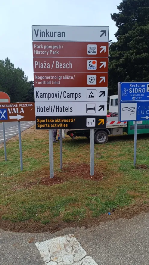 Smeđa i bijela turistička signalizacija s putokazima za Vinkuran, plaže, kampove i hotele.