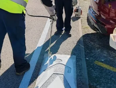 Djelatnici tvrtke Ličilac d.o.o. koriste šablonu i strojni pištolj za precizno iscrtavanje simbola pješaka